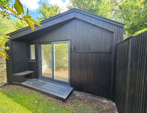 The garden room has been clad in charcoal colour Thermowood with a triple shadow gap profile